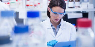 Scientist refers to chemical inventory management software on her tablet