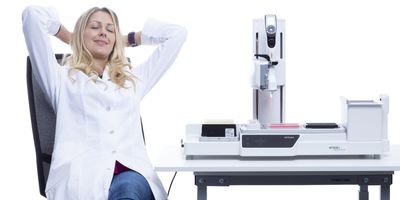 A researcher relaxing thanks to an automated liquid handling system, on a white background